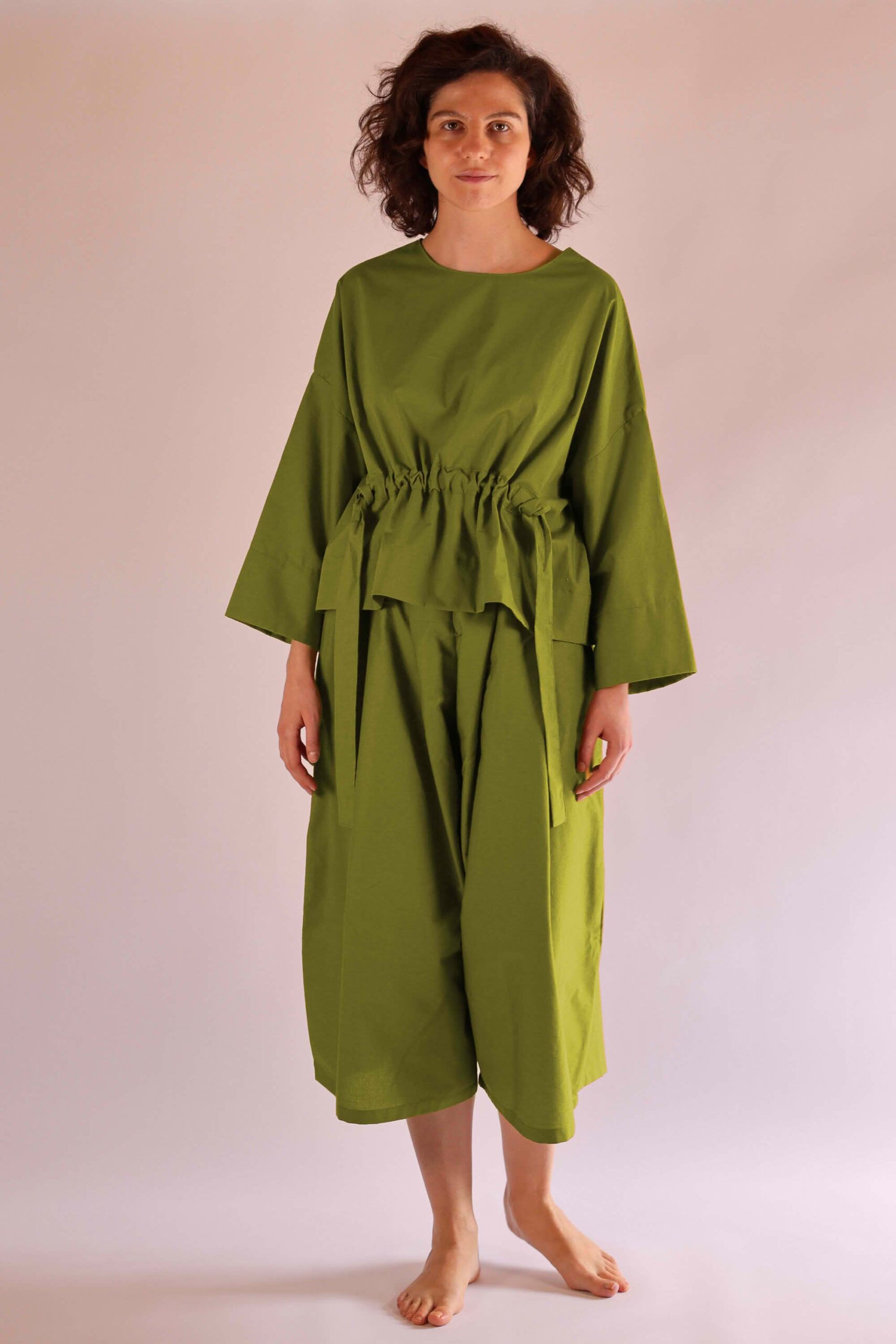 Kurze Oversized-Damenbluse mit Tunnelzug-Detail und weite Culotte-Damenhose mit tiefen Hosenfalten in Olivgrün aus nachhaltiger Biobaumwolle, hergestellt in der Schweiz